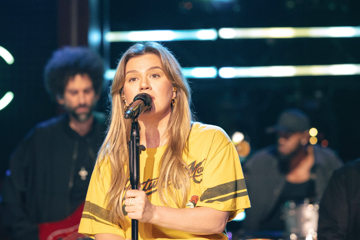 Kelly Clarkson wearing a yellow graphic T-shirt during an earlier live performance; archival context image, not the Brooklyn store footage
