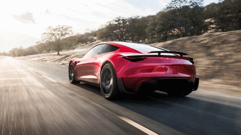 Red Tesla Roadster concept photographed from the rear three-quarter angle
